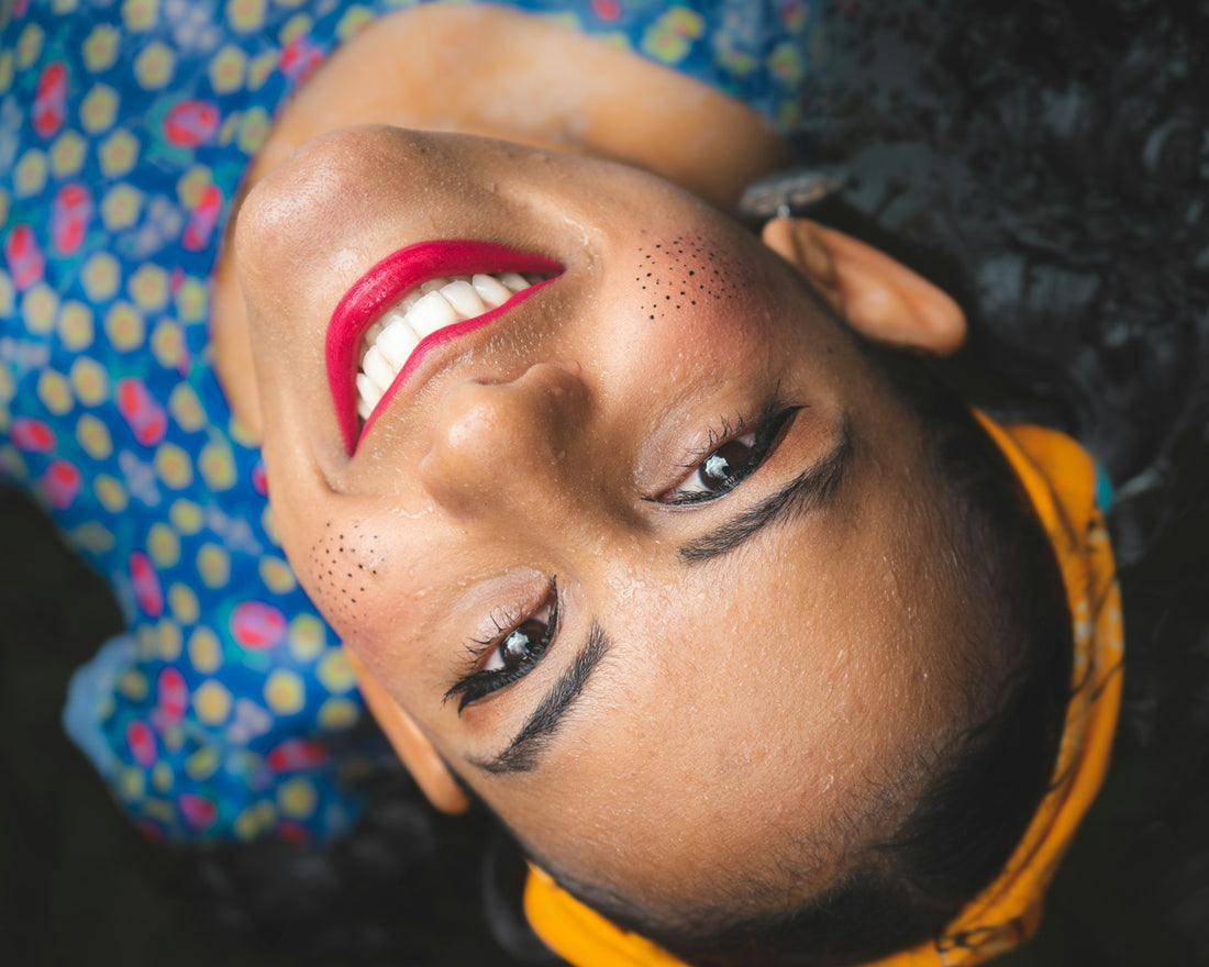 A vibrant woman smiling confidently with strong, white teeth, symbolizing enamel protection.