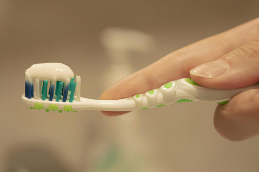 "Close-up of a toothbrush with toothpaste being applied, highlighting proper dental hygiene routine."