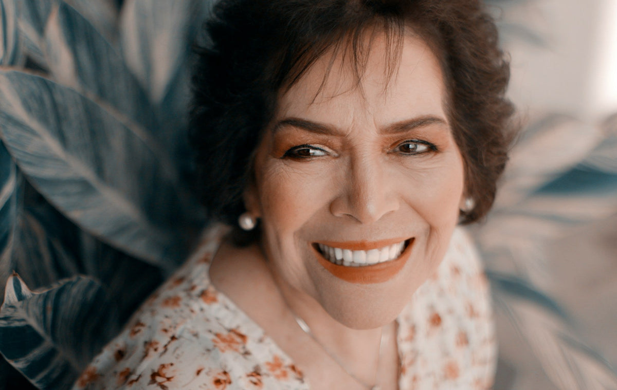 Portrait of an older woman confidently smiling with bright white teeth, showcasing safe and effective whitening results.