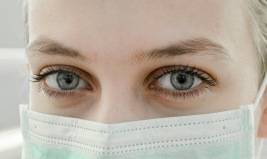 Close-up of a healthcare professional's eyes wearing a surgical mask, symbolizing medical expertise and safety standards in dental care.