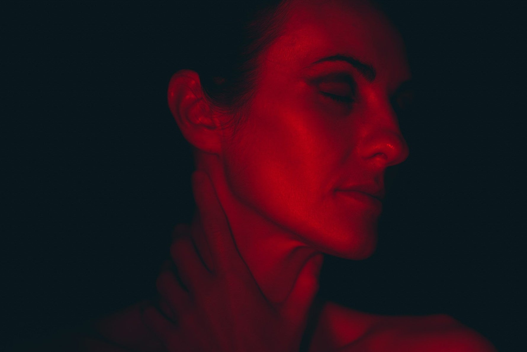 Woman receiving red light therapy for skin rejuvenation and relaxation, showcasing the therapeutic benefits of red light for a radiant, youthful appearance.
