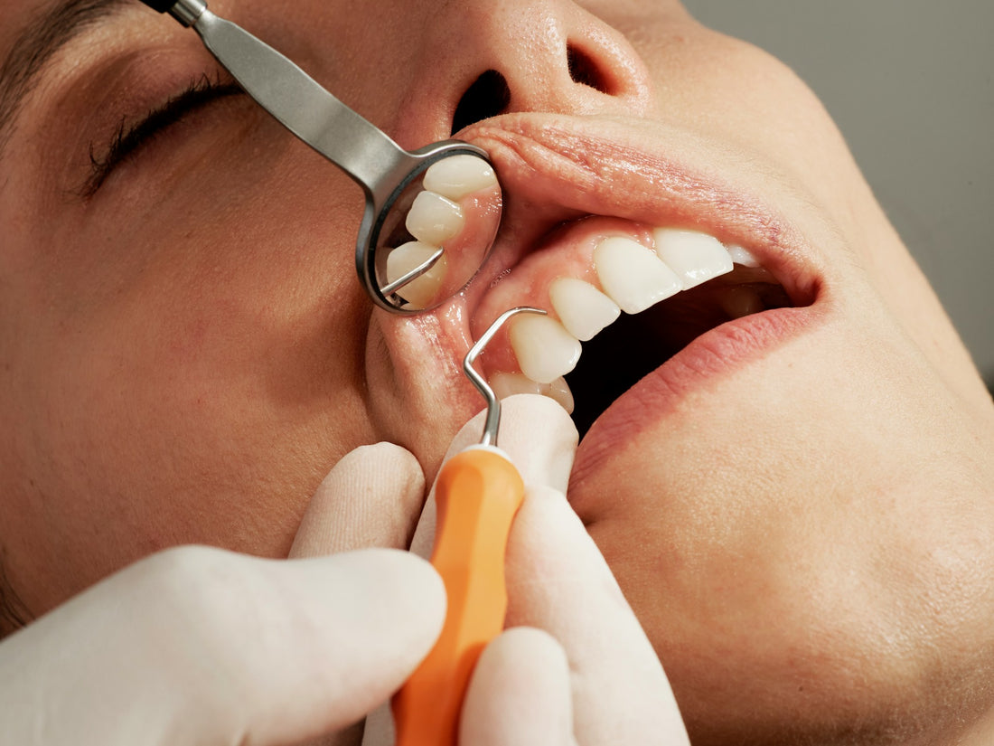 Close-up of a dental professional examining a patient’s gums with dental tools to examine gum health